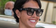 a woman wearing sunglasses is smiling for the camera