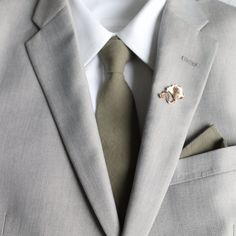 a man wearing a suit and tie with a pin in his lapel