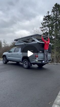 a man standing on the back of a truck with an awning over his head