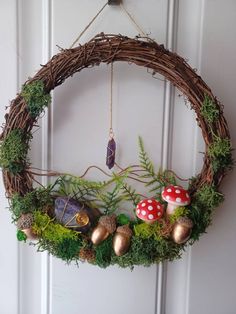 a wreath is hanging on the door with mushrooms and ferns around it, along with other decorations