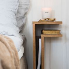 a bedside table with a lamp and books on it