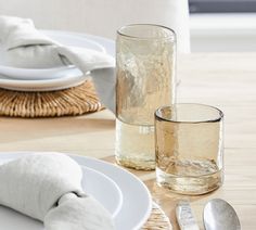 a table set with plates, silverware and napkins