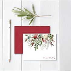 a red envelope with white flowers and greenery on it, next to a pencil