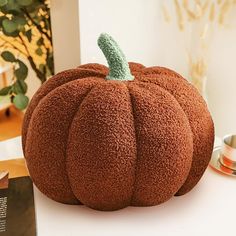 a pumpkin shaped pillow sitting on top of a table