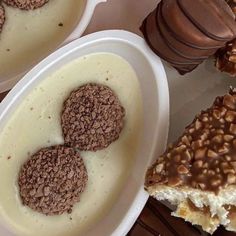 there are three desserts in white bowls on the table