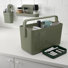 a kitchen counter with two green baskets on it and some utensils in them