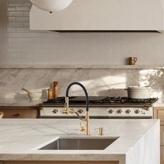 a kitchen with marble counter tops and an island in front of a stove top oven