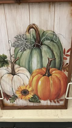 a wooden sign with pumpkins and sunflowers painted on it