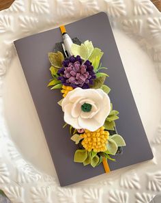 a white plate topped with a notebook covered in flowers