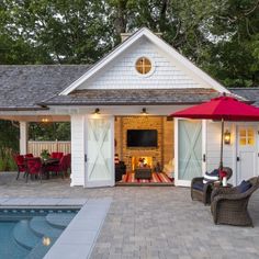 a pool house with an outdoor kitchen and dining area next to the pool is shown