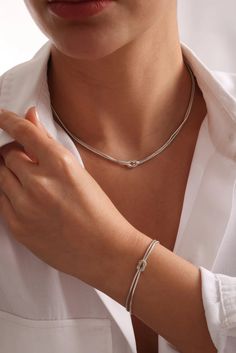 The Dainty Silver Knot Necklace  is the perfect blend of elegance and symbolism. Featuring a delicately crafted knot pendant, this necklace represents the unbreakable bond between loved ones or the strength within yourself. Its minimalist design adds a touch of subtle sophistication, making it an ideal accessory for both casual and formal outfits. Whether as a meaningful gift or a personal keepsake, the Dainty Silver Knot Necklace  is a timeless piece that embodies connection, unity, and enduring strength.   Details:     Material:  Made from high-quality sterling silver , offering both durability and a polished finish that shines with elegance.   Knot Design:  The delicate knot symbolizes the strength of relationships and life's intertwined moments, perfect for marking a special connection Modern Jewelry With Sliding Knot As Gift, Gift Round Pendant Necklace With Sliding Knot, Lariat Necklace With Sliding Knot As A Gift, Lariat Necklace With Sliding Knot For Gifts, Lariat Necklace With Sliding Knot, Sliding Knot Lariat Necklace For Gift, Elegant Adjustable Necklaces With Spring Ring Clasp, Silver Jewelry With Sliding Knot For Everyday, Elegant Lariat Jewelry With Sliding Knot