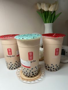 three cups with blue and red sprinkles on them sitting on a table