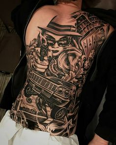 the back of a man's upper half covered with tattoos and artwork on his body