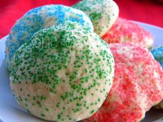 some colorful cookies on a white plate with sprinkles