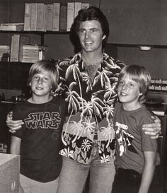 an old black and white photo of three boys in front of a desk with books on it