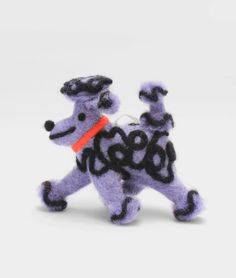 a purple and black dog ornament on a white background with an orange collar