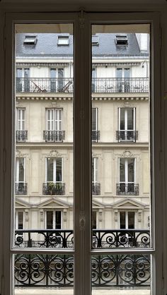 an open window in front of a building with balconies