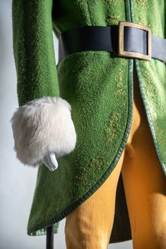 a close up of a green coat with fur on it