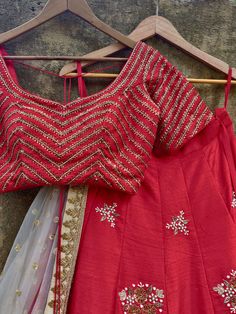 This gorgeous bridal red raw silk lehenga with sequins, stone and zardozi hand embroidered big butti is paired with a red blouse with chevron hand work. This outfit is complete with a nude sequins net dupatta with beige border. Red Raw Silk Sets With Gota Work, Fitted Red Choli With Gota Work, Red Dola Silk Embroidered Fabric For Party, Red Dola Silk Choli With Gota Work, Red Chinon Lehenga With Resham Embroidery, Festive Red Choli With Gota Work, Red Gota Work Choli For Reception, Festive Red Lehenga With Dori Work, Red Raw Silk Lehenga For Festive Occasions