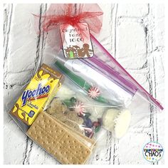 a bag filled with candy, crackers and other items sitting on top of a table