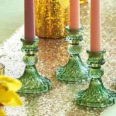 four green candles are sitting on the table