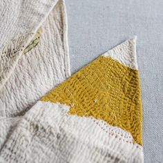 a yellow and white piece of cloth sitting on top of a table