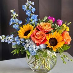 a vase filled with lots of different colored flowers