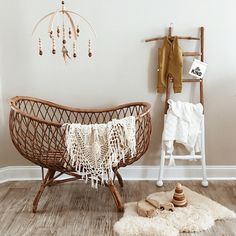 a baby crib in the corner of a room next to a ladder and coat rack