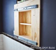 a bathroom with blue walls and white tile on the wall is being built in an unfinished cabinet