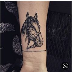 a black and white horse tattoo on the left wrist with a line work style design