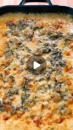 a casserole dish with cheese and spinach in it on a wooden table