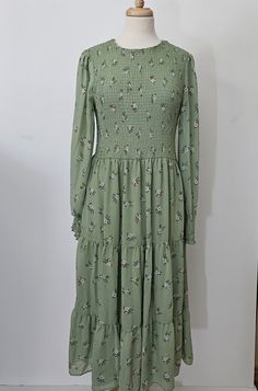 Maxi dress with a sheared  bodice front and back, pull on style . Lined from the waist to 9" from the hem skirt has  three ruffles. A pretty all season dress in very good vintage condition , Sized x large photographed on a size 10 mannequin  fits a 10 / 12.  Bust 36 / 38"  Waist  34 "  Length shoulder to hem 48"  * Care  Hand Wash Cold Water  Hang To Dry  or  Dry Clean Fitted Smock Tiered Midi Dress, Fitted Tiered Midi Dress With Smock Detail, Fitted Tiered Smock Midi Dress, Fitted Smock Dress With Tiered Skirt, Green Smocked Bodice Tiered Skirt Dress, Long Sleeve Smock Dress For Garden Party, Hem Skirt, Green Print, Hippie Style