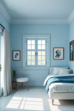 a bedroom with blue walls and white bedding, two pictures on the wall above the bed