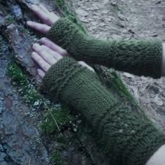 someone is holding their hand out in the woods with moss growing on it's fingers