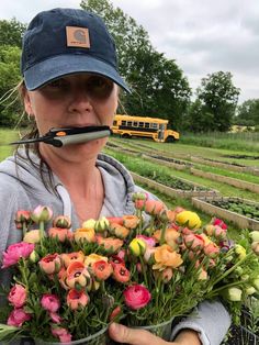 a woman holding a bouquet of flowers in front of a school bus on the road