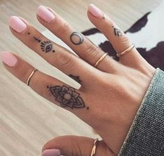 a woman's hand with two tattoos on her left and one on the right