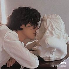 a young man is kissing a doll on the table