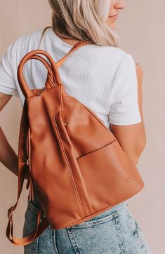 We are always looking for a bag that everyone will love. This might just be it! Enter our convertible backpack. This bag comes with a stylish clever zipper strap, it goes from backpack to crossbody, has a convenient top handle and can even be wore on the shoulder. It's the middle ground between our Hazel and Nikki. Yes, this bag is just that good!! Bag Details: Made with Premium Vegan Leather Dims: 11" BASE 4" TOP W X 13.5" H X 5.5" D Weight: 1.12 lbs. Exterior Features: 1 Front Padded Pocket 1 Everyday Leather Satchel Backpack For Fall, Everyday Fall Backpack Shoulder Bag, Trendy Everyday Satchel For Back To School, Fall Standard Backpack For Everyday Use, Everyday Fall Shoulder Backpack, Everyday Fall Standard Backpack, Fall Everyday Use Standard Backpack, Everyday Use Fall Standard Backpack, Fall Satchel Backpack For Everyday Use