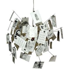 an art piece with many pictures hanging from it's sides and notes attached to the strings