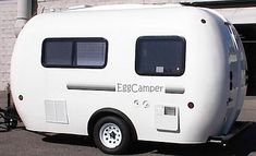 an electric camper parked in front of a building