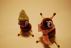 two toy snails with hats and scarves on their heads