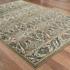 a large rug with an intricate design on top of wooden floors in a living room