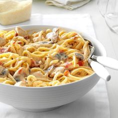 a white bowl filled with pasta and meat