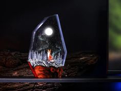 a glass sculpture with a red fox in the woods under a full moon