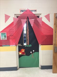 an open door to a classroom with red and white checkered umbrellas on it