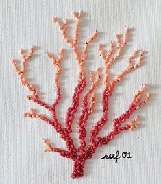 an embroidered coral is shown on a white piece of cloth with the word sea life written across it