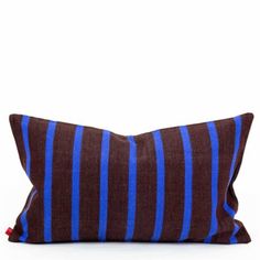 a brown and blue striped pillow sitting on top of a white floor