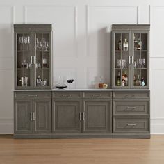 two gray cabinets sitting next to each other on top of a hard wood floor