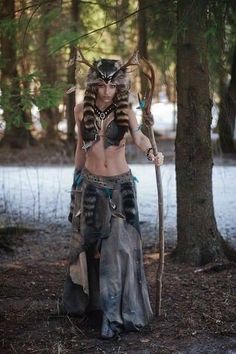 a woman dressed up as a warrior in the woods