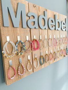 a wooden sign that says madewell with lots of bracelets hanging on the wall